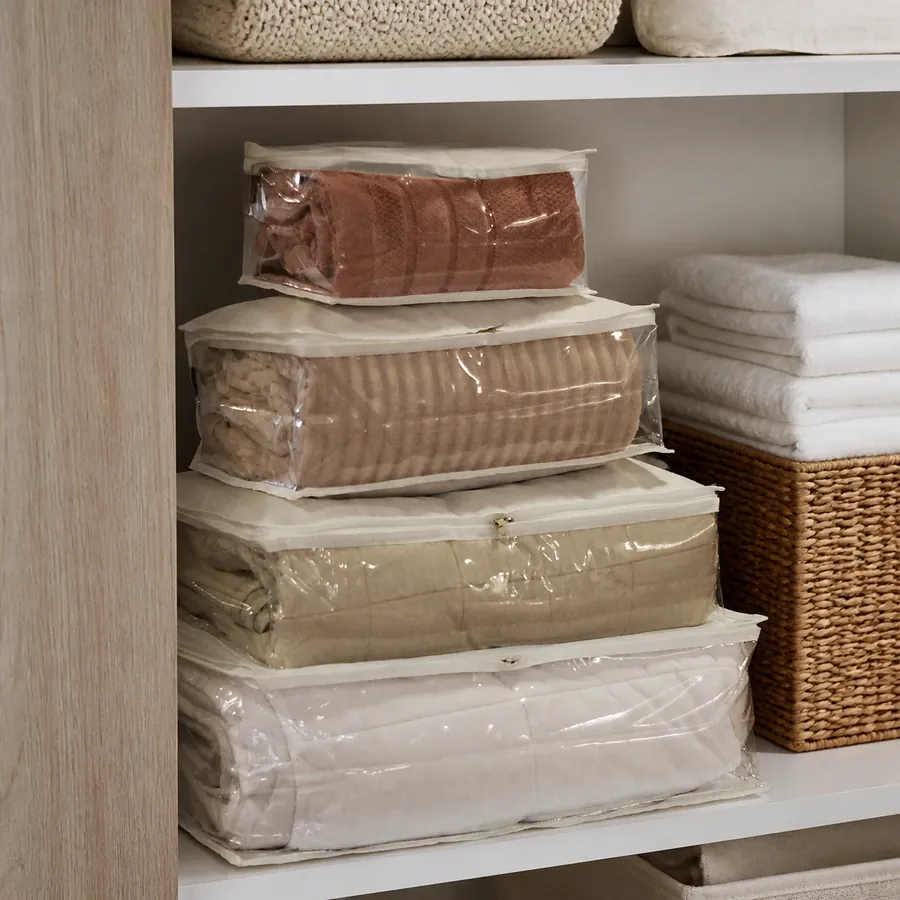 Capas organizadoras com edredons e roupas de cama numa prateleira